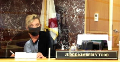 Pictured is Pinellas-Pasco Circuit Judge Kimberly Todd, who presides over adult drug court cases in Pinellas County. The photo was taken Wednesday, Oct. 21, in her courtroom at the County Justice Center in Clearwater as she was going through that morning's calendar. Out of view are a correctional probation officer from the Department of Corrections, a prosecutor, an assistant public defender and members of drug court's staff. In addition to wearing a mask, Judge Todd is surrounded by plexiglass, as evidenced by the reflective quality of the picture.